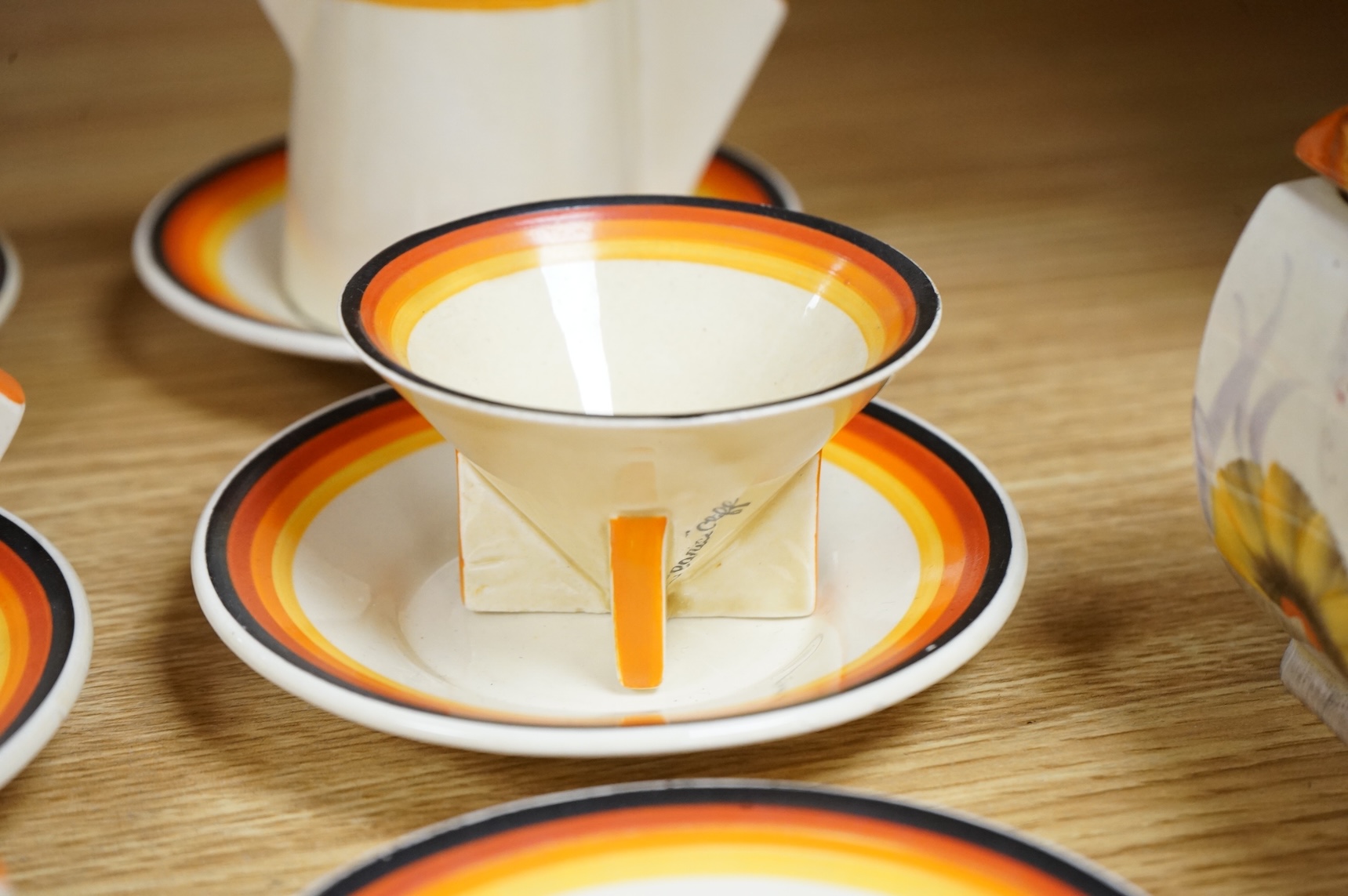 An Art Deco Clarice Cliff Bizarre part coffee set and a similar Rhodanthe-pattern preserve pot and cover, largest 11cm high